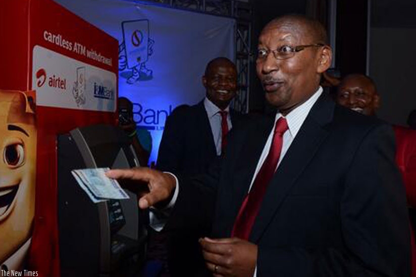 Central bank chief John Rwangombwa withdraws at an I&M Bank ATM using Airtel Money. The card-less withdrawal is facilitated by RSwitchu2019s e-payment services (File)