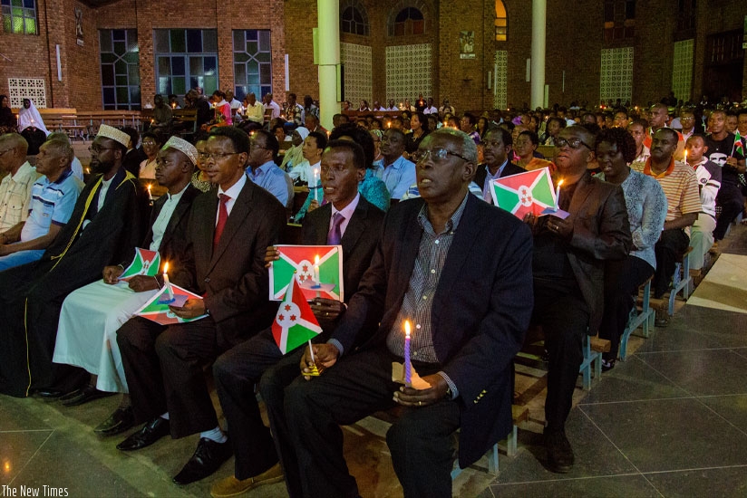 Burundian refugees pray holding their national flag and candles at Regina Pacis Parish in Kigali yesterday.  (All photos by Faustin Niyigena)