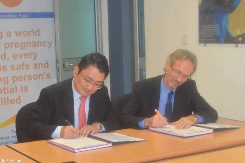Amb Yong-min (R) signs the Memorandum of Understanding with UNFPA Country representive,  yesterday. (Peterson Tumwebaze)