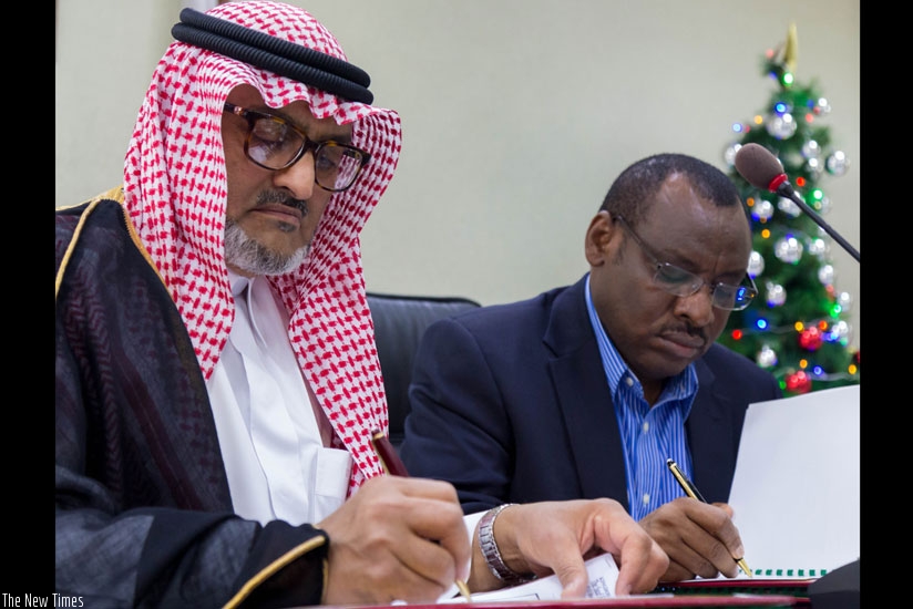 Eng. Hassan Al-Attas, the director-general of Operations, Saudi Fund for Development (L), and Finance and Economic Planning minister Claver Gatete sign the funding deal for Nyagatare-Rusumo road construction in Kigali yesterday. (Timothy Kisambira)
