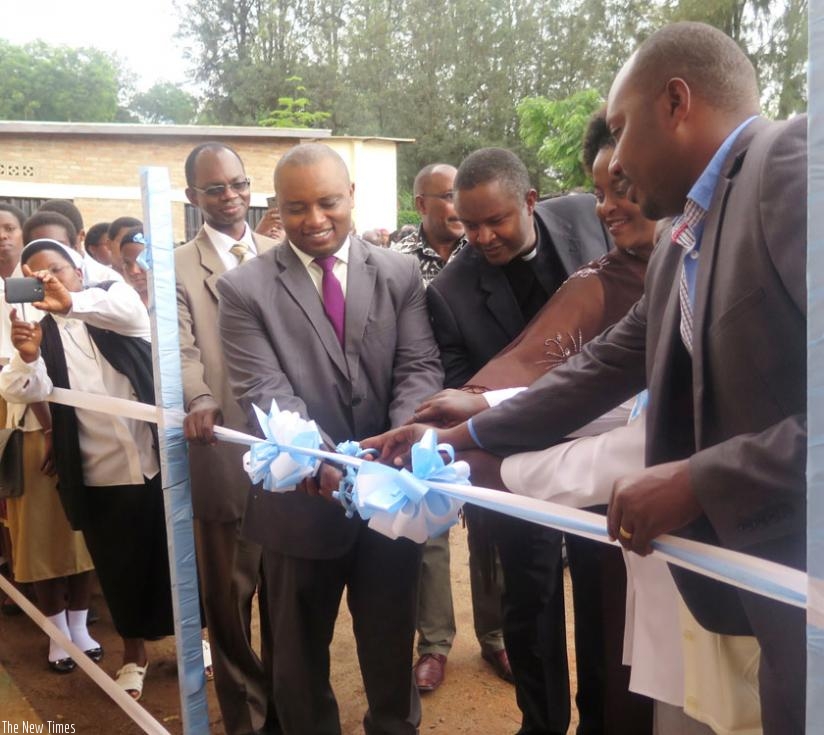Rwamukwaya (C), with parents and other officials cut the ribbon to open the dormitory. (F. Byumvuhore)