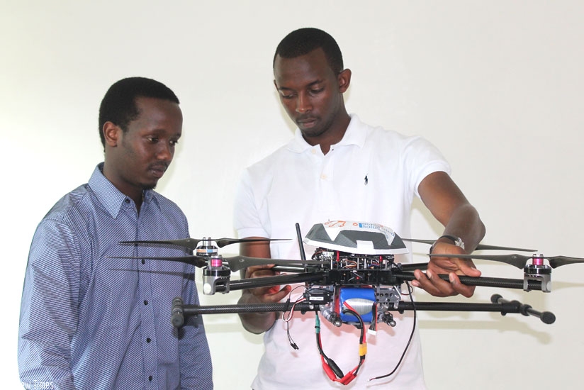 Rutayisire (left) and Segore show off one of the drones. (Moses Opobo)
