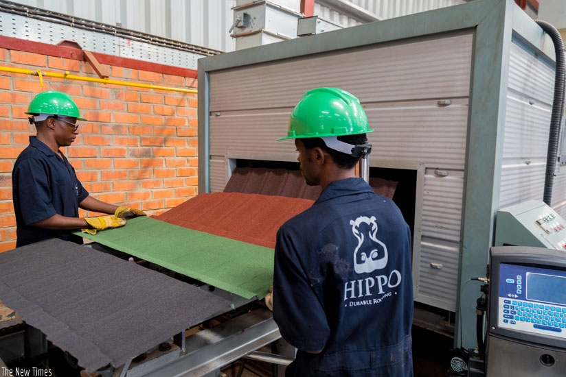 Workers monitor the production process of stone coated steel roofing tiles at Hippo factory in the Kigali Special Economic Zone. The tiles are made by S&H Industries Rwanda. (Timothy Kisambira)