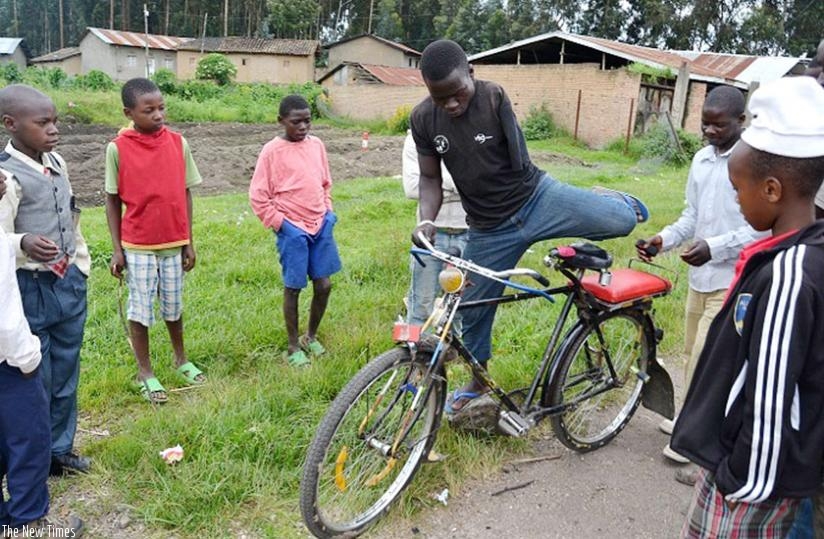 Onlookers marvel at Imanirakiza as he prepares to take a passenger in Mukamira Centre. (Jean d'Amour Mbonyinshuti)