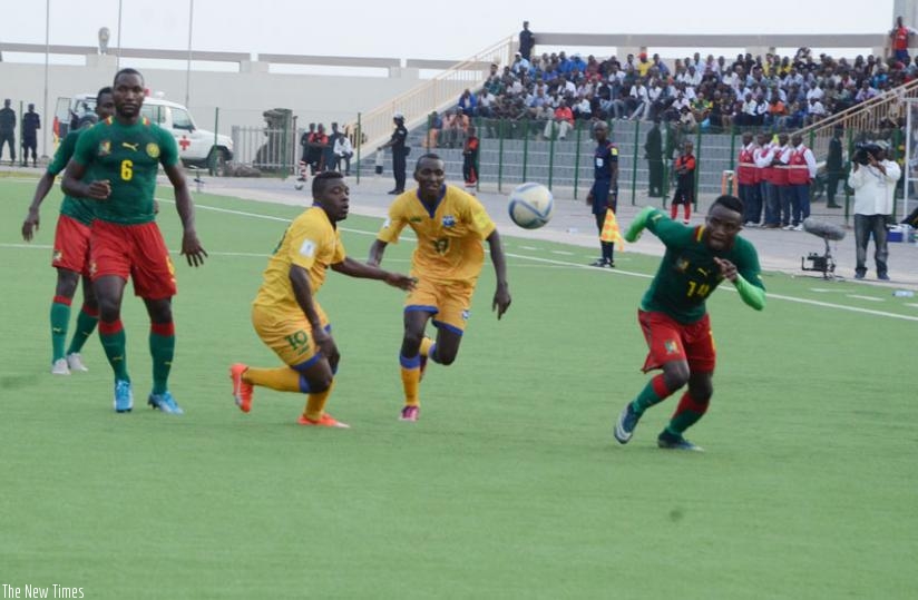 Rwanda forwards Isaie Songa and Innocent Habyarimana sprint for the ball as Cameroon defenders mark them during yesterday's match at Umuganda stadium. (S. Ngendahimana)