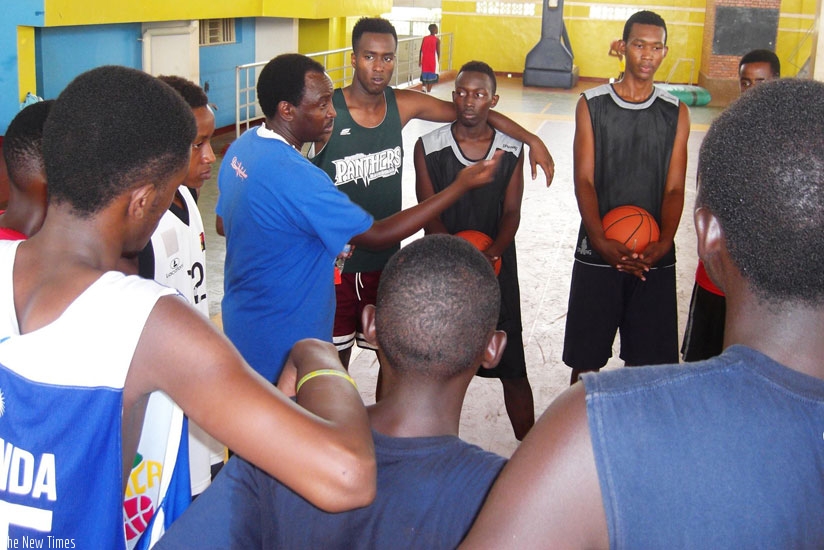 The U-18 national  team coach Moize Mutokambali speaks to his players during a training session earlier this week at Amahoro indoor stadium. (Courtesy)