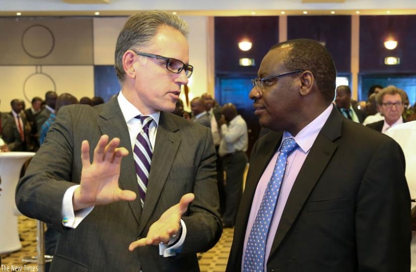 John F. Vitalo, Atlas Mara chief executive (L), chats with Minister Gatete in Kigali yesterday. (Timothy Kisambira)