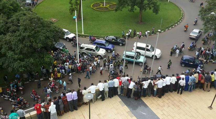People watch the scene of incident from the balcony of Pension Plaza in Kigali yesterday. (Courtesy)
