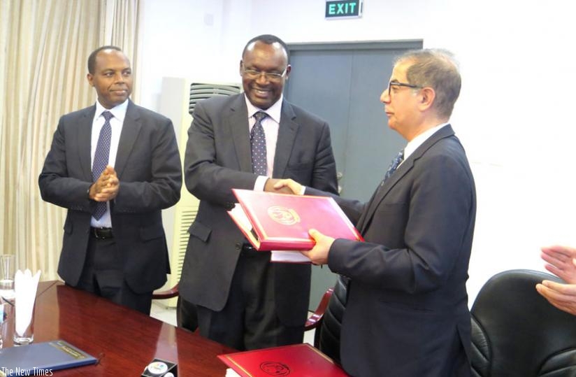 Trade and Industry minister Francois Kanimba (C) and Suhail Albanna, senior vice president and managing director of Dubai Port World in Middle East and Africa region (R) exchange paperwork after signing an agreement that will see the construction of Kigali Logistics Platform in Masaka Sector. Applauding is Rwanda Development Board chief executive Francis Gatare. (Michel Nkurunziza)
