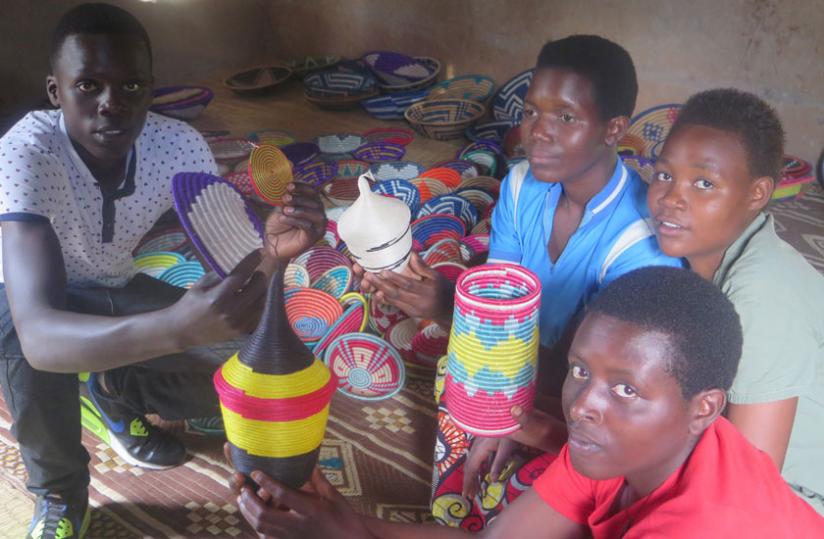 The youngsters pose for a picture with some of the items they make. The teens work under the tutelage of Ruhango's Berwa Women's Association found in Byimana sector. (Stephen Nuwagira)