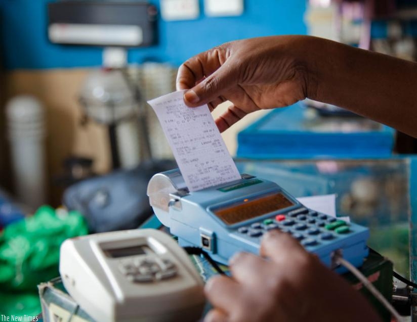 A trader pulls a receipt out of an electronic billing machine at Mateos in downtown Kigali. (T. Kisambira)