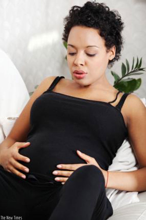 A pregnant woman massages her stomach. (Net photo)
