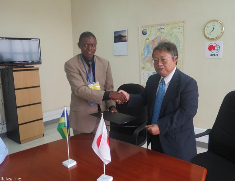 Sakamoto (R)  and  Rutaremara shake hands after signing the grant deal at the Japanese embassy in Kigali, yesterday. (Micheal  Nkurunziza)