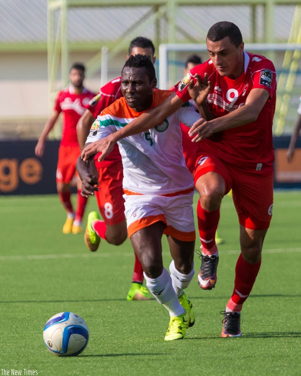 Niger's defender Musa Shehu (L) vies for the ball with Tunisian striker Ahmed Akaichi. Tunisia won 5-0 at Kigali Regional Stadium. (Timothy Kisambira)