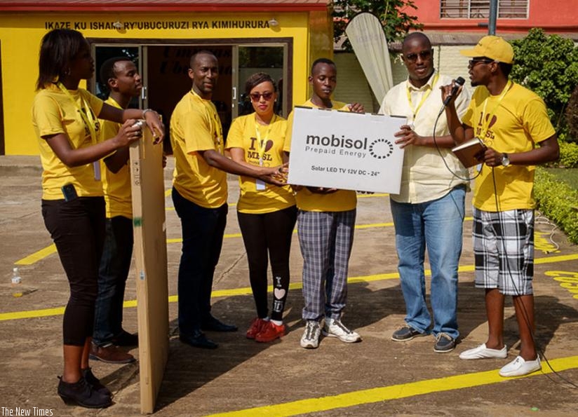 Misago (third left) receives the solar system from Mobisol officials last week. Misago is the firm's 10,000th client. (Courtesy)