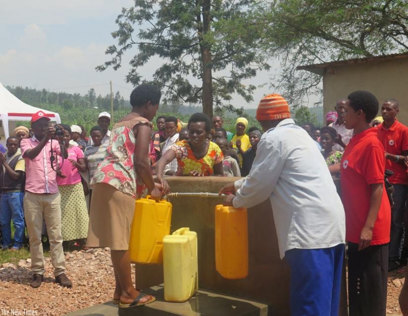 The residents fetch water from the new facility yesterday. They will no longer walk long distances to fetch water. (Julius Bizimungu)