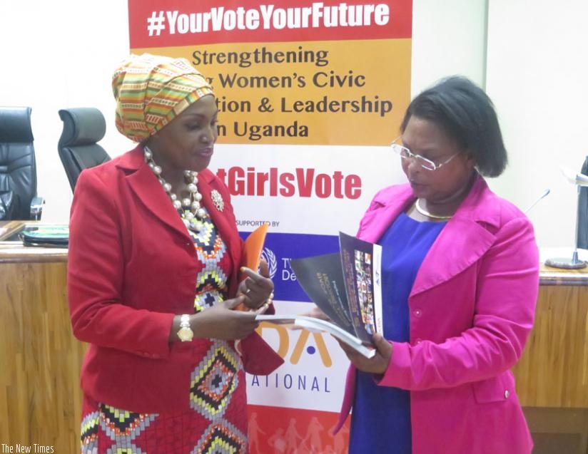 Rehmah Kasule (L) gives MP Euthalie Nyirabega books that contain activities of CEDA International, an organisation that aims at empowering women in politics yesterday, in Kigali. (John Mbaraga)