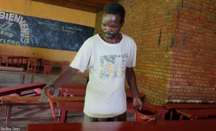 Emmanuel Munyandamutsa paints furniture at Nyange Secondary School in Nyange Sector, Ngororero District on Thursday, Januaryy 28, 2016.