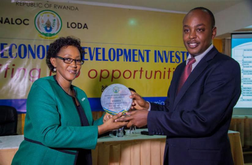 Stella Ford Mugabo, Minister for Cabinet Affairs hands over the second award to Abdalah Murenzi, Nyanza mayor for the best development investment projects competition last year. (File)