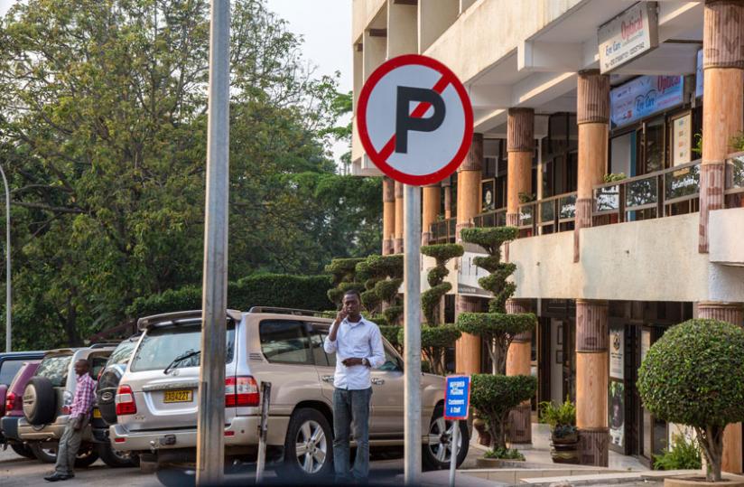 As a result of inadequate parking space in Kigali city, motorists have started violating road sign. Cars parked at the no stopping sign along KN 84 Street opposite Hotel Isimbi. (Doreen Umutesi)