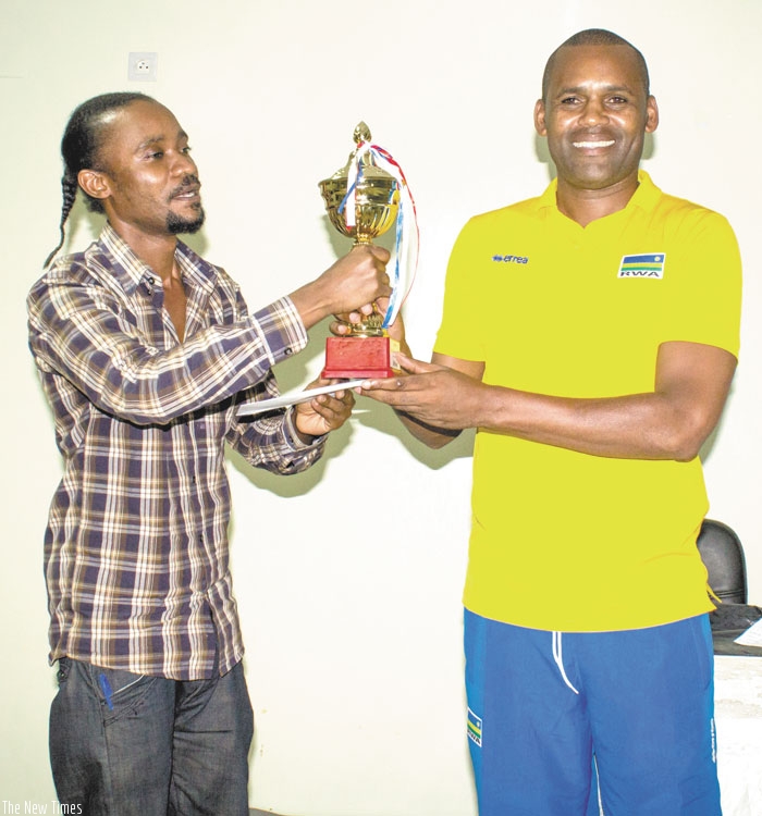 Kagabo, left, receiving the winner's trophy from RNOC's Elie Manirarora. (J. Karuhanga)