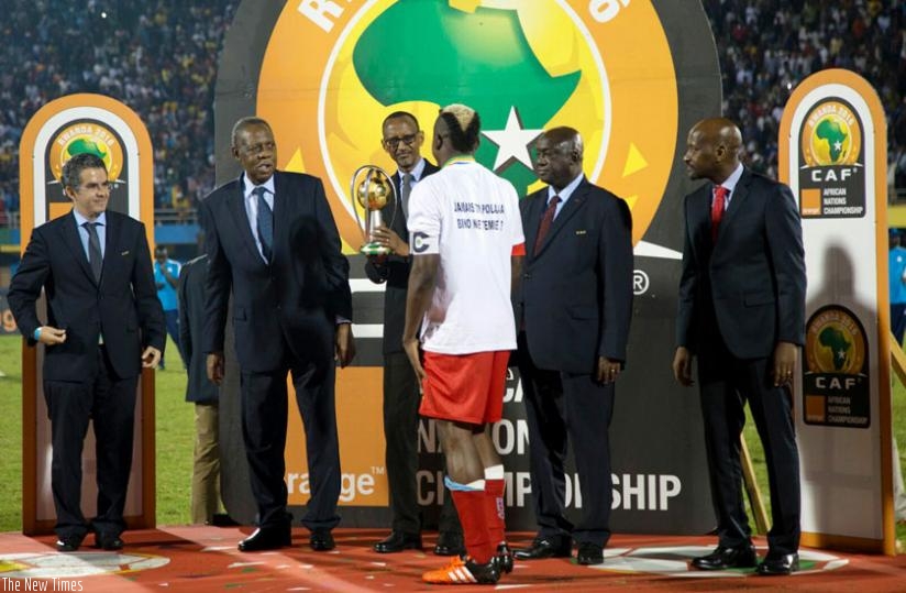 President Kagame hands over African Nations Championships trophy to DR Congo captain Joel Kimwaki as CAF's Secretary General Hicham El Amrani ( L), Issa Hayatou, president of CAF, Almany Kabele, second vice-president of CAf (2nd R), and FEREWAFA president Vincent Nzamwita look on yesterday. (Timothy Kisambira)