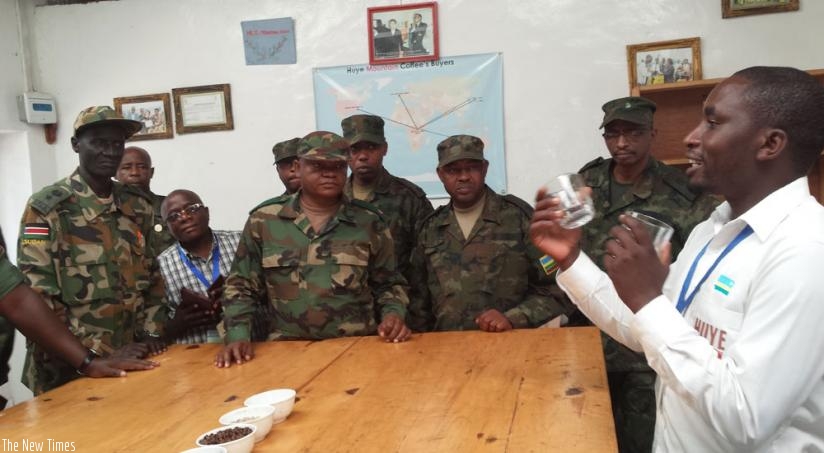 A Huye Mountain Coffee worker explains coffee processing  to the Rwanda Defence Force Command and Staff Callege students at the factory in Huye District. (Emmanuel Ntirenganya)