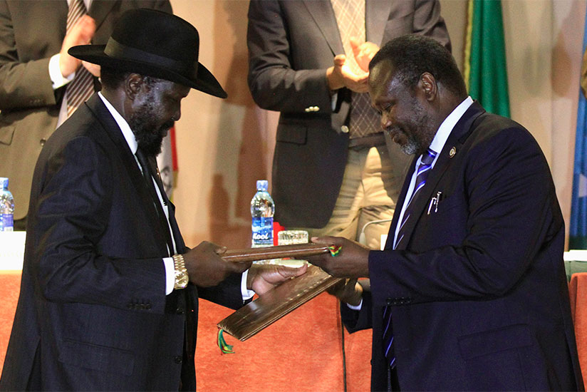 South Sudan's President Salva Kiir (L) and rebel commander Riek Machar exchange documents after signing a ceasefire agreement during the Inter Governmental Authority on Development (IGAD) Summit on the case of South Sudan in Addis Ababa, Feburary 1, 2015. (Internet photo)