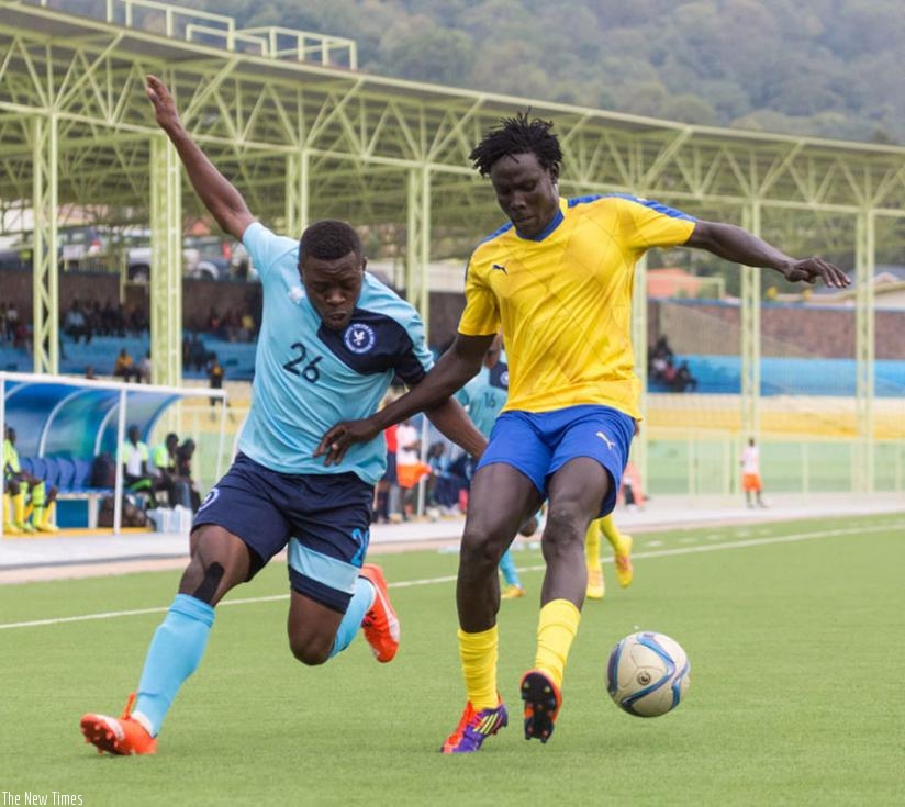 Police striker Songa Isaie (L) fights for the ball with Altabara FC defender Deng Magik Deng at Nyamirambo Regional Stadium on Saturday. (T. Kisambira)