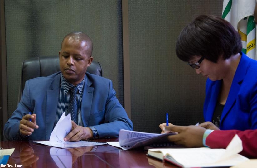 The Director General of Workforce Development Authority, Jerome Gasana (L), and Ann Xoi Wey, the acting general manager of C&H Garments, sign an agreement paperwork in Kigali yesterday. (Timothy Kisambira)