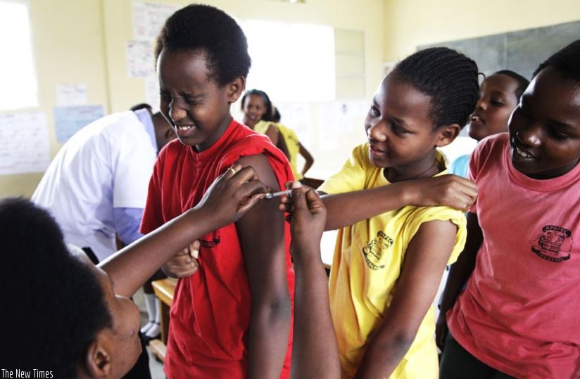 A nurse at Kagugu Health Centre Immunises pupils of APAPEC IREBERO Primary School. (Timothy Kisambira)