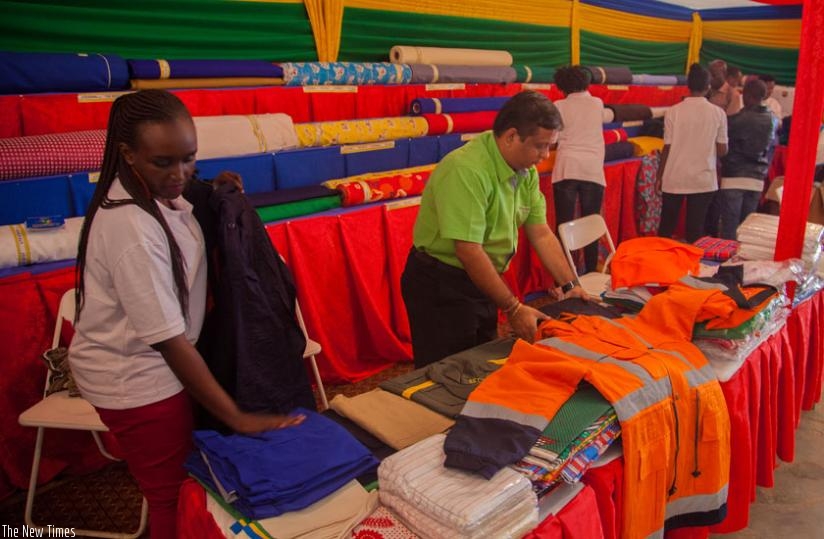 Textiles maker, Utexrwa staff arrange clothes at the expo yesterday.  Some exhibitors were still setting up stalls by midday yesterday. (Faustin Niyigena)