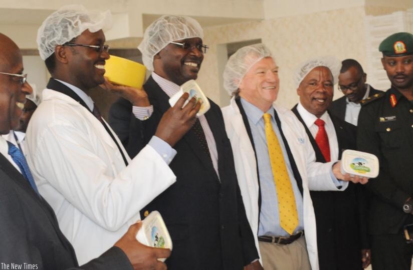 Minister Kanimba (2nd L) poses for photo with other officials showing cheese made from Burera dairy on Wednesday. (Michel Nkurunziza)