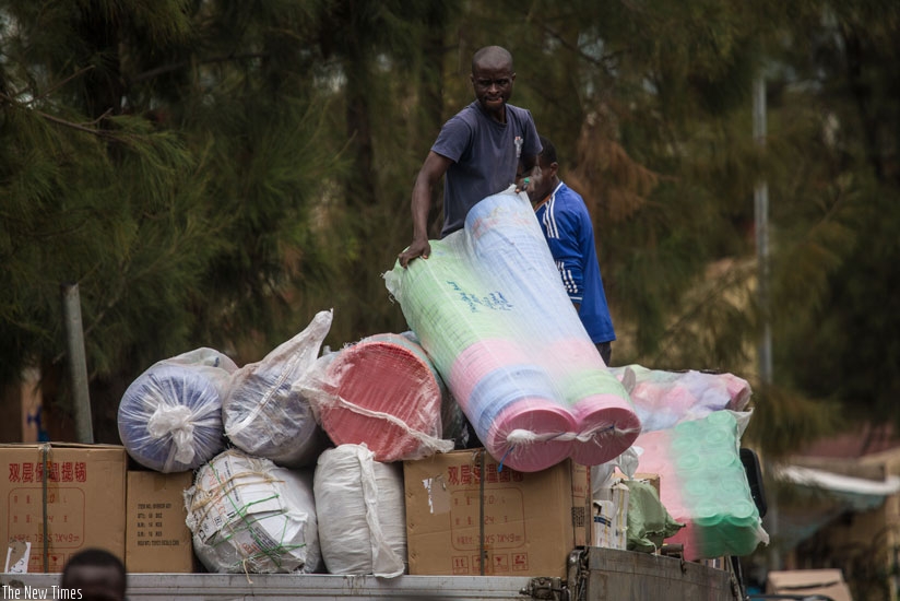 People pack their merchandise as they relocate from Quartier Mateus yesterday. (Timothy Kisambira)