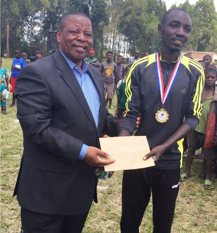 Nizeyimana (L) receiving the winner's prize from the Governor  of Nothern Province,  Aime Bosenibamwe. (G. Assimwe)