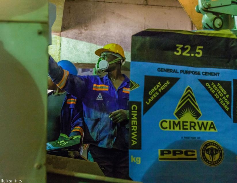 Cimerwa workers man a production line. The firm is struggling to compete with imported cement. (Timothy Kisambira)