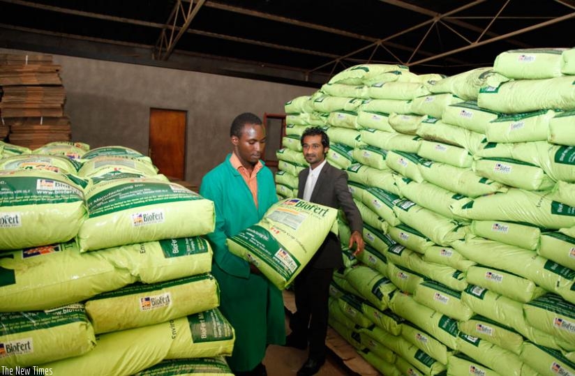 A worker lifts a bag of fertilisers at a store in Gikondo. (Timothy Kisambira)