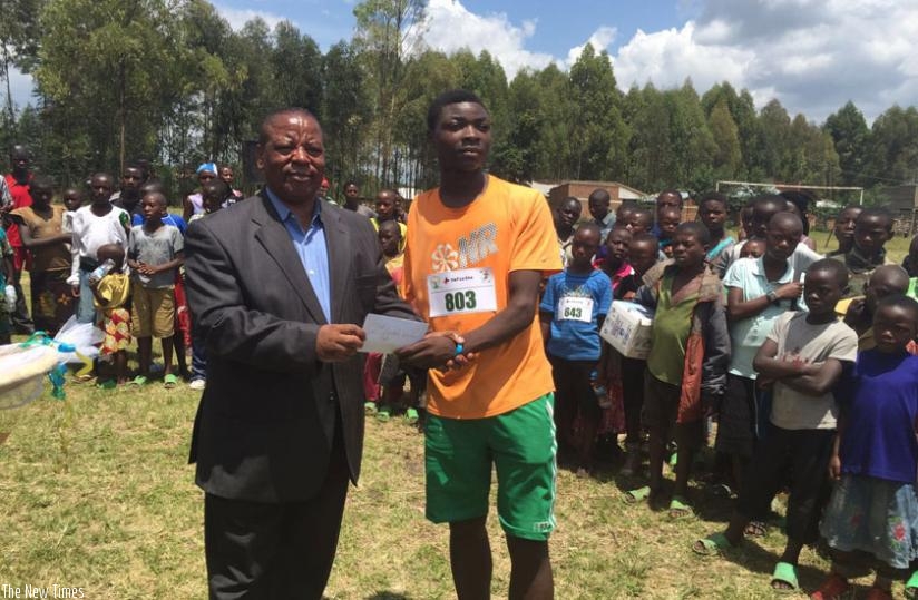 Niyibizi receiving an award from Aime Bosenibamwe, Governor Northern Province. (G. Asiimwe)