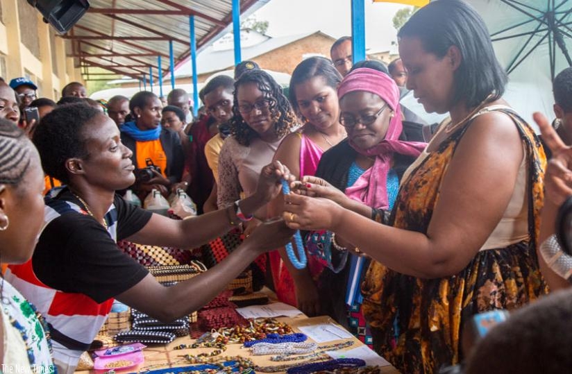 Minister Gasinzigwa (R) takes a look at the products women were showcasing at the celebrations in Nduba yesterday. (Doreen Umutesi)