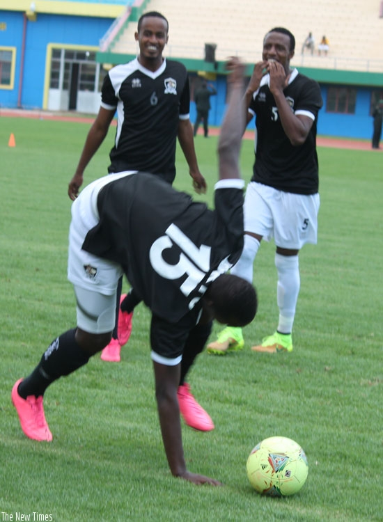 APR players Yannick Mukunzi and Emery Bayisenge share a light moment as a teammate stumbles during a training session on Thursday at Amahoro stadium. (P. Kamasa)