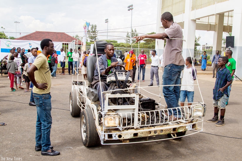 Eric Hakizimana, a teacher at EMVTC a vocational school in Remera, showcases a car that was put together by his students during the youth connect  dialogue last year. The EAC has commissioned a study on the auto industry. (File)