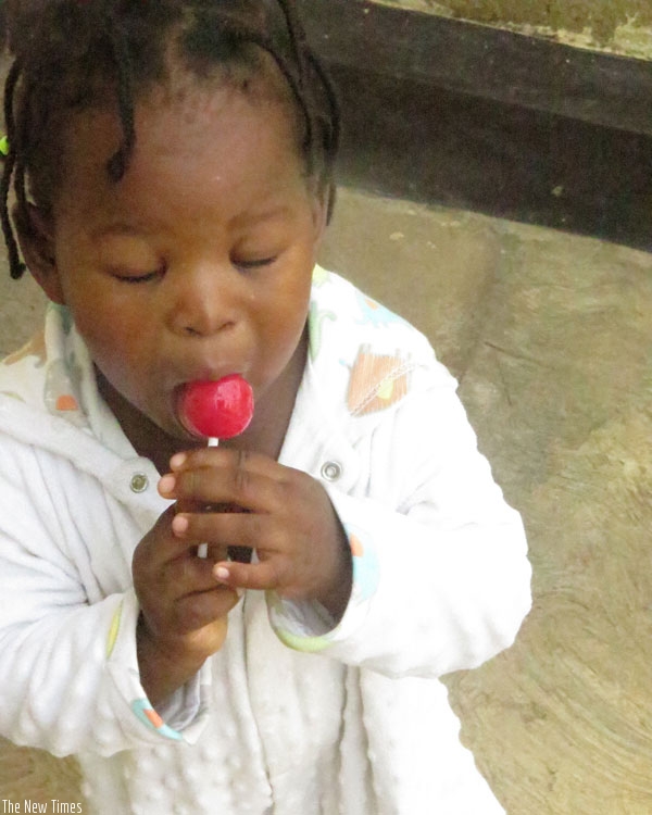A child licks a sweet. Excessive consumption of sweet substances is a major cause of tooth decay in both children and adults. (Lydia Atieno)