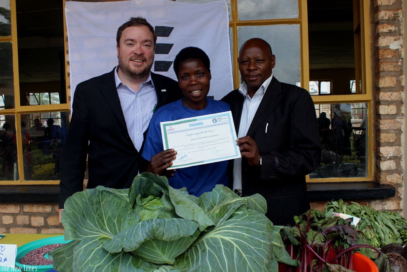 Clessence Mukanyandwi (C) receives a certificate after completing behaviour change training of trainers from John Ames (L) and Laurien Jyambere on Thursday. (Courtesy)