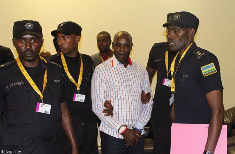 Rwanda National Police officers attached to the National Public Prosecution of Rwanda take custody of Ntangazwa at Kigali International Airport yesterday. (Courtesy.)