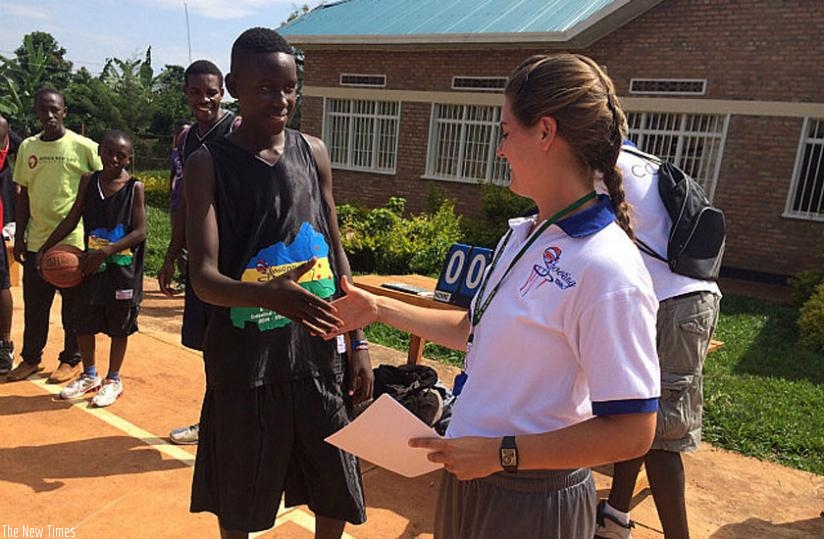 Lindsey Kittredge handing over certificates to young basketballers after training session in Kayonza. (Courtesy)