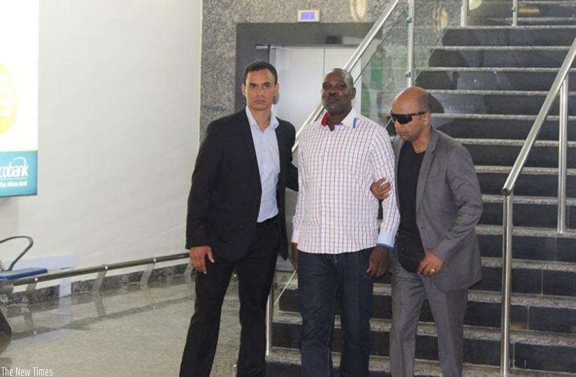 Genocide suspect Ntaganzwa (C) arrives at Kigali International Airport during his extradition on Sunday. (Courtesy)