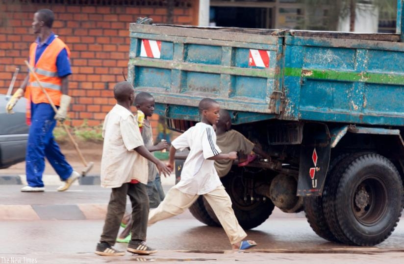 Street children at Nyabugogo try to climb a moving truck. (File)
