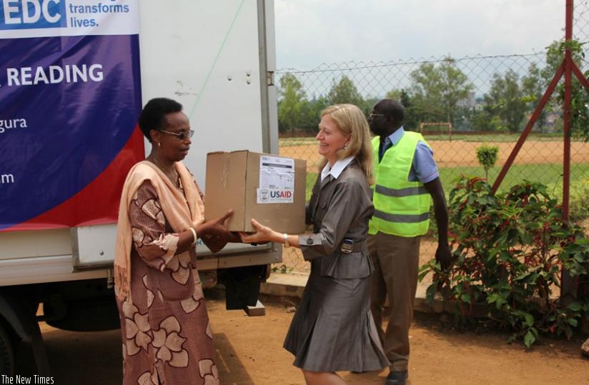 Gasinzigwa receives the teaching and learning materials from Amb. Barks-Ruggles at Ecole Primaire d'Application de Kimihurura  in Kigali, yesterday. (Courtesy)
