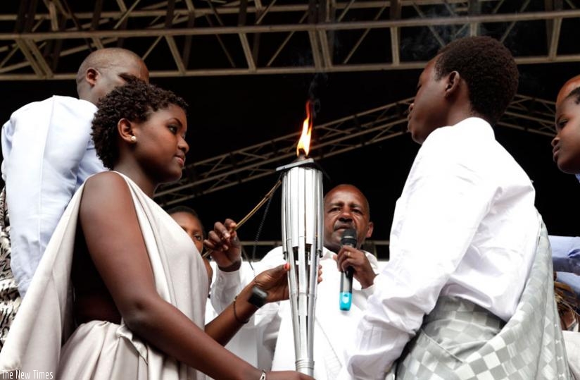 The Kwibuka Flame is held by twenty-two-year old at Kigali Memorial Center in 2014. (File)