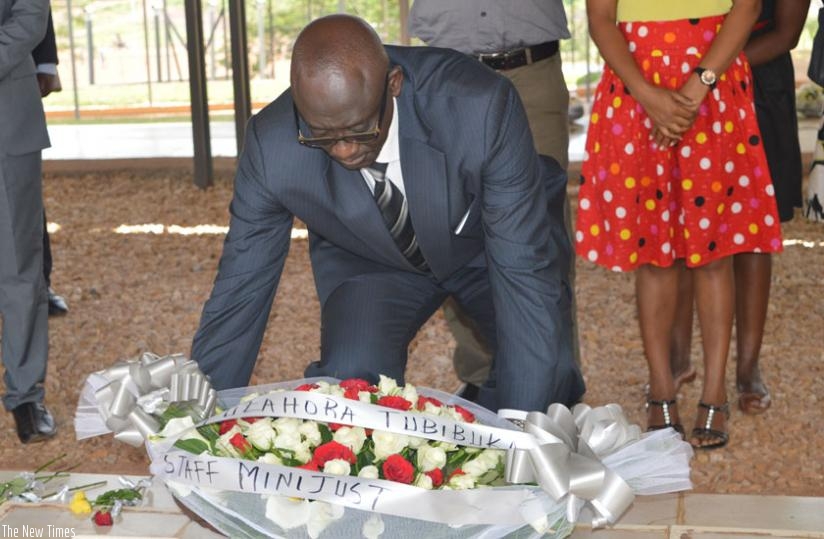 Minister Busingye lays a wreath on a grave at Nyanza-Kicukiro Genocide memorial on Monday. (J. Mbaraga)